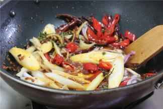 接着下洋葱、小米椒、姜片、大葱继续翻炒