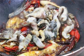 放一勺泡椒水，把鱼块下进去一起翻炒5分钟左，根据口味加花椒面、盐炒匀即可出锅