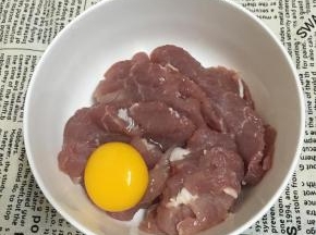 里脊肉切薄片，放入碗中，打入鸡蛋用手抓匀。