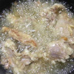 锅中加入多一些的油，大火烧至8分热，下入肉片中火炸至呈金黄色捞出。