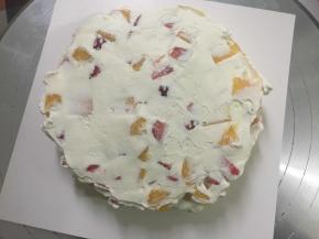 接着再抹上一层奶油，这样一层水果奶油夹心就做好了，接着又一层蛋糕坯一层水果奶油夹心……一直把2层水果夹心和3片蛋糕坯，完整放好