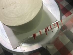 用软刮片修整过的抹面会漂亮很多……蛋糕纯白感觉单调了点，所以我在软刮刀上弄点红色色素，然后抹在蛋糕侧面，做成间色效果