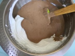 将翻拌好的蛋糕糊倒入到剩余的蛋白霜中，用刮刀翻拌均匀。