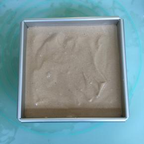 将拌好的蛋糕糊倒入方形模具中，轻轻的晃动几下，再用力震几下，震出大气泡。