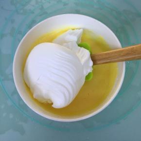 取三分之一的蛋白霜到蛋黄糊里，用刮刀翻拌均匀。