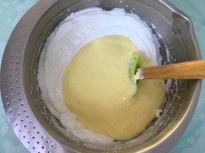 将翻拌好的蛋糕糊倒入到剩余的蛋白霜中。