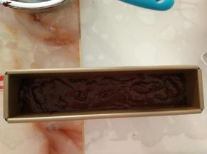 拌好的面糊用裱花袋挤入模具中。