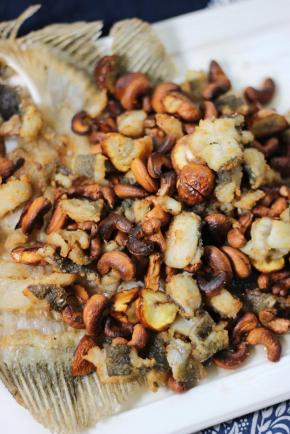 将炒好的鱼肉和坚果盛到鱼骨上装盘即可