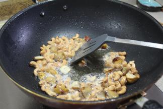 接着把准备好的腰果、板栗放入锅里炒香