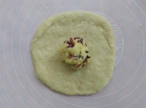 取其中一个面团轻轻压扁，放入一小勺的奶酥馅