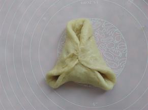 把面皮的边提起来，像包糖三角一样，包起来，先把中间捏紧