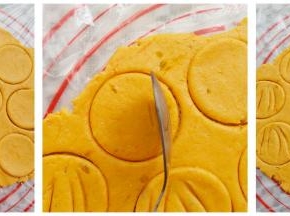 南瓜面团擀成一个大面饼，用一个大的圆形工具印出饼干胚，用勺子立起来在饼干胚上印4条缝（多出来的边角碎料我用来做手指饼干，也可以继续擀出来做南瓜饼干）