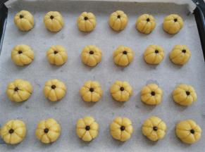 把所有的饼干面团转移到烤盘上，饼干面团上放一颗耐烤巧克力或葡萄干