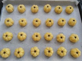 把所有的饼干面团转移到烤盘上，饼干面团上放一颗耐烤巧克力或葡萄干