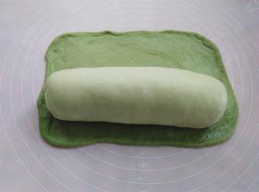 绿色面皮擀平，把上一个原色面团卷进去