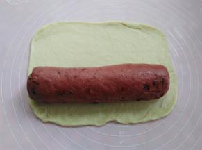 取原色面皮擀平，把红色面团卷进去，原色的面团不用擀太大，把红色面团卷一圈就可以了