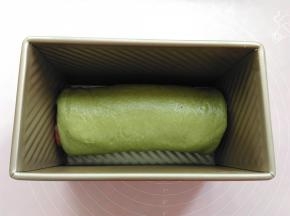 把卷好的面团放到土司盒里，放进烤箱发酵