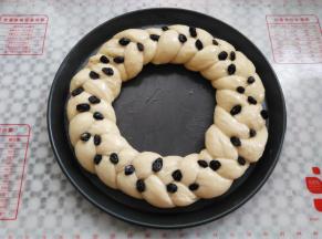 面团转入12寸披萨盘中。烤箱发酵30分钟，取出放上黑加仑装饰，刷一层薄的蛋液，同时预热烤箱160度