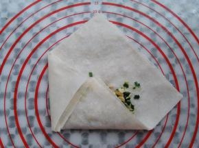 春卷皮的左侧往右折，接口处可以抹一点水更好的沾合在一起