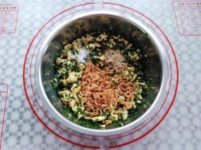 装有鸡蛋的盆里加入韭菜，食用油，虾米，盐，白胡椒粉搅拌均匀