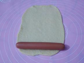 面皮放上火腿肠，从下往上卷。