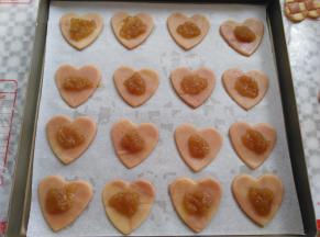 饼干底小心的转到烤盘里，每个饼干底放上一小勺的苹果酱