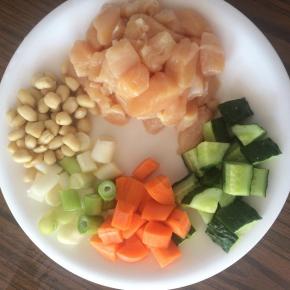 准备食材，鸡胸肉切成1cm左右的小块，黄瓜、胡萝卜切小丁。花生提前用开水浸泡5分钟，剥去外皮。