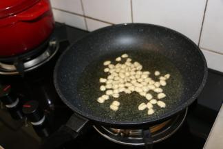 锅内倒入适量食用油，小火炸至花生米酥脆，捞出晾凉备用。