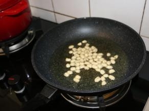 锅内倒入适量食用油，小火炸至花生米酥脆，捞出晾凉备用。
