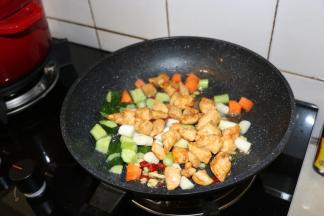 放入鸡肉丁、黄瓜丁、胡萝卜丁翻炒1分钟。
