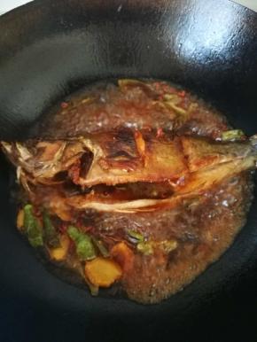 炒出香味后，放入煎好的鱼，料酒，生抽，老抽，蚝油放入，翻炒一下，倒入水，烧开后，加锅盖调到中火，开始焖煮，中途可以打开锅盖，把鱼翻面，尝下汤的咸淡，看是否需要加盐。
