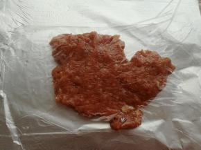 取一张40cm长度的油纸，在油纸上抹一层油，放上一半的肉沫，盖一层保鲜膜