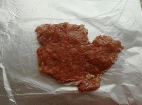 取一张40cm长度的油纸，在油纸上抹一层油，放上一半的肉沫，盖一层保鲜膜