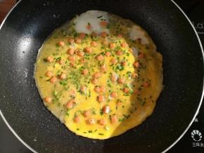 煎到面糊半透明的时候淋上一层蛋液，再撒适量的野葱碎