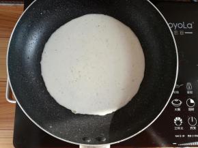 不粘锅里刷一点点油，倒入适量的面糊，平铺满锅底