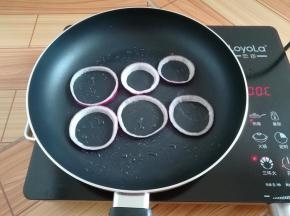 不粘锅里刷一点点油，放入洋葱圈小火加热
