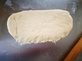 将面团光滑面朝下，擀成椭圆形，