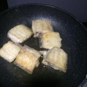 平底锅内倒入适量食用油，放入沾满干淀粉的带鱼段，小火煎制。