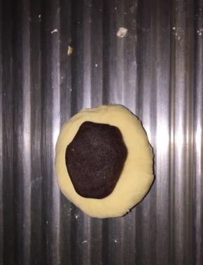 取面团一半大小的红豆沙搓成球，包进面团里，搓圆，按扁