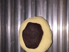 取面团一半大小的红豆沙搓成球，包进面团里，搓圆，按扁