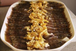 5、在蒸好的豆腐上摆上处理好的虾，浇上剩下的调味汁，上锅蒸5分钟