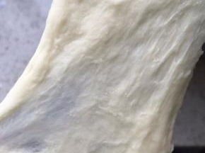 此时面团已经有一点延展性了，能拉出比较厚的膜，比较糙，容易断裂，此时把软化的黄油丢进去，继续4档揉，开始加黄油面团非常粗糙，时间久了，面团会非常光滑，加入黄油后，四档揉面12-15分钟左右