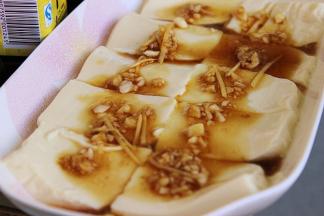 4、豆腐切片摆在盘子里，浇上一半刚调好的汁，上锅蒸两分钟