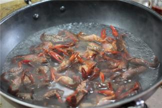 锅上烧水，将小龙虾倒入锅中淖水，捞出沥干。