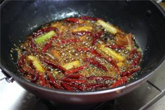 锅置火上，油锅加少许油，烧热，下郫县豆瓣、大葱段、干辣椒、香料炒香。