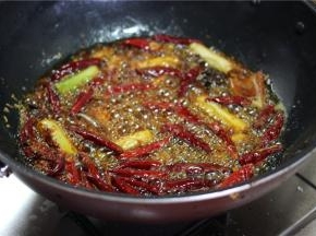 锅置火上，油锅加少许油，烧热，下郫县豆瓣、大葱段、干辣椒、香料炒香。