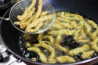 将肉条糊下油锅，先开大火加热油温，然后转小火炸定型，捞出