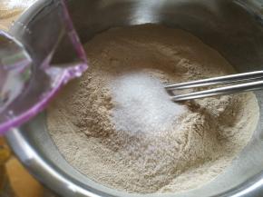 加入细砂糖，倒入温水，一边倒一边用筷子搅拌。