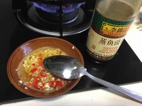 热油倒进蒜蓉里，用勺子搅匀。