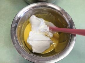 这时打开烤箱预热，温度为170度，取1/3蛋白霜放入蛋黄液中。
